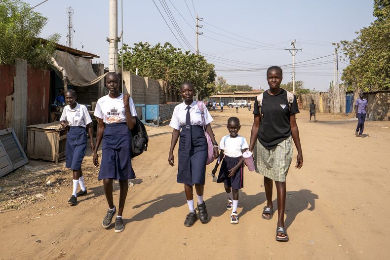 Estudiantes caminan de vuelta a sus casas en Juba, Sudán del Sur, el viernes 21 de febrero de 2025 tras ser enviadas por la escuela debido a una ola de calor que ha causado que algunos estudiantes se desmayen. (AP Photo/Florence Miettaux)