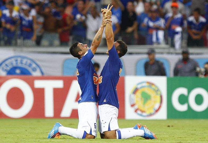Egidio (izquierda) y Ceara, del Cruzeiro de Brasil, celebran el tercer gol contra la Universidad de Chile, en un partido disputado el martes 25 de febrero de 2014, por la Copa Libertadores (AP Foto/Bruno Magalhaes)