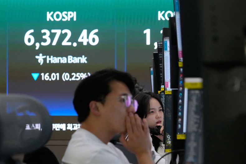 Un corredor de divisas habla por teléfono junto a una pantalla en la que se muestra el Índice Compuesto de Precios de Acciones de Corea (KOSPI) en la sede central del Hana Bank en Seúl, Corea del Sur, el miércoles 22 de abril de 2026. (AP Foto/Ahn Young-joon)