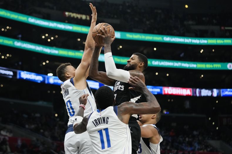 Paul George, de los Clippers de Los Ángeles, dispara frente a Dante Exum, de los Mavericks de Dallas, en el encuentro del sábado 25 de noviembre de 2023 (AP Foto/Jae C. Hong)