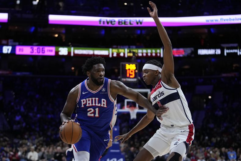 Joel Embiid, izquierda, de los 76ers de Filadelfia, intenta superar la marca defensiva de Bilal Coulibaly, de los Wizards de Washington, durante la priemra mitad del juego de baloncesto de la NBA, el lunes 11 de diciembre de 2023, en Filadelfia. (AP Foto/Matt Slocum)