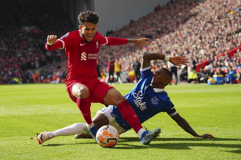 El delantero colombiano Luis Díaz de Liverpool se lleva un balón frente a Ashley Young de Everton en el partido de la Liga Premier disputado el sábado 21 de octubre de 2023. (AP Foto/Jon Super)