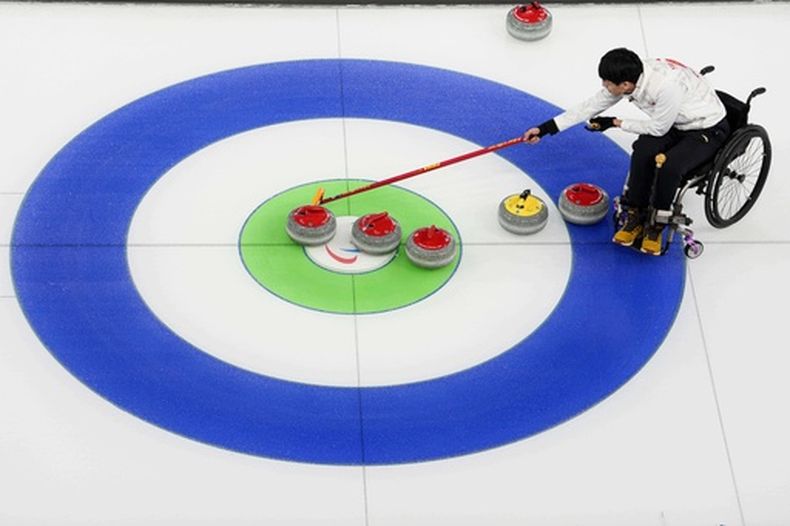 El chino Jinqiao Yang compite en el curling mixto sobre silla de ruedas ante Italia, durante los Juegos Paralímpicos de Invierno en Cortina dAmpezzo, Italia, el jueves 5 de marzo de 2026 (AP Foto/Evgeniy Maloletka)