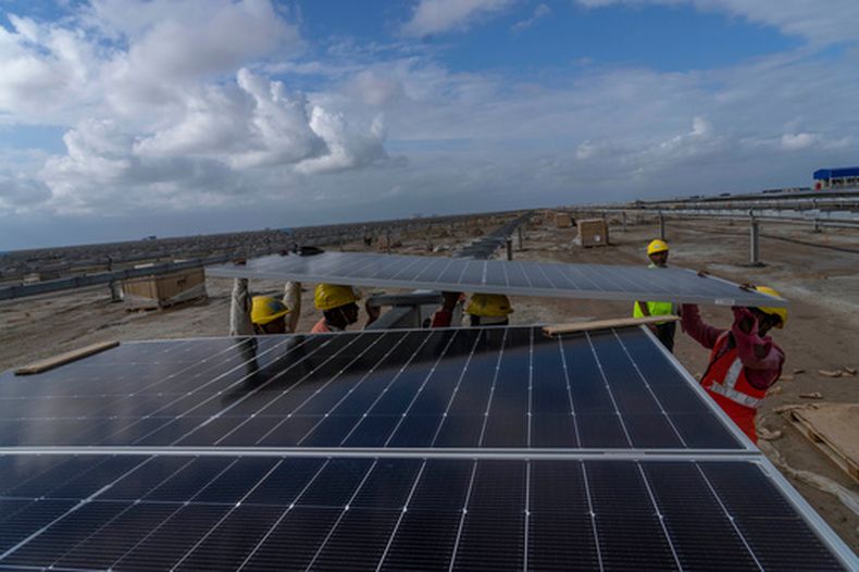 ARCHIVO - Trabajadores instalan paneles solares en el Parque de Energía Renovable de Adani Green Energy Limited —actualmente en construcción— el 21 de septiembre de 2023, en el desierto de sal de la aldea de Karim Shahi, cerca de Khavda (distrito de Bhuj), próximo a la frontera entre India y Pakistán, en el estado occidental de Gujarat, India. (AP Foto/Rafiq Maqbool, Archivo)