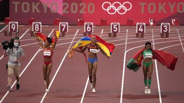 La venezolana Yulimar Rojas (centro) festeja tras conquistar el oro e imponer el récord mundial en salto triple durante los Juegos Olímpicos en Tokio, el 1 de agosto de 2021 (AP Foto/Charlie Riedel)