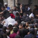 Palestinos se reúnen para recibir bolsas de harina distribuidas por la UNRWA, la agencia de la ONU que ayuda a los refugiados palestinos, en Deir al Balah, en el centro de la Franja de Gaza, el sábado 2 de noviembre de 2024. (AP Foto/Abdel Kareem Hana)