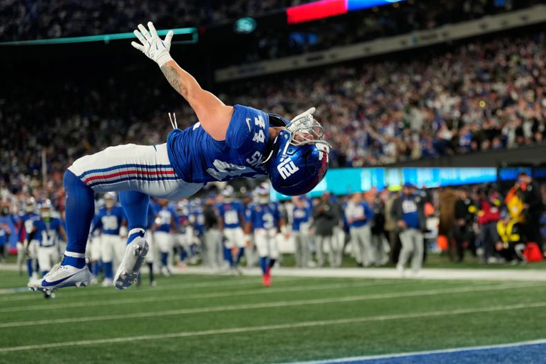 Cam Skattebo, de los Giants de Nueva York, realiza un salto mortal tras anotar un touchdown ante los Eagles de Filadelfia, en el partido del jueves 9 de octubre de 2025 (AP Foto/Seth Wenig)
