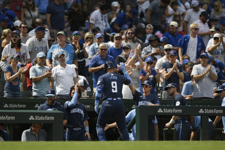 El panameño de los Cubs de Chicago, Miguel Amaya celebra con el mánager Craig Counsell (centro a la derecha) en el banco luego de impactar un jonrón solitario durante la quinta entrada del juego de béisbol ante los Azulejos de Toronto, en Chicago, el viernes 16 de agosto de 2024. (AP Foto/Paul Beaty)
