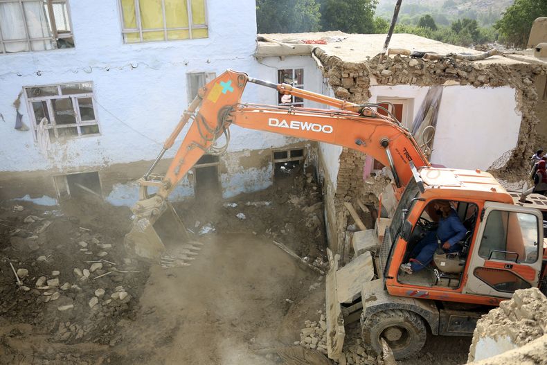 Una excavadora saca tierra en una vivienda dañada por inundaciones en la provincia Maidan Wardak, Afganistán, el 23 de julio de 2023.. (Foto AP)