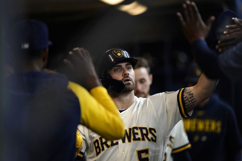 Garrett Mitchell, de los Cerveceros de Milwaukee, recibe las felicitaciones en la cueva luego de anotar en el juego del jueves 28 de septiembre de 2023, ante los Cardenales de San Luis (AP Foto/Aaron Gash)