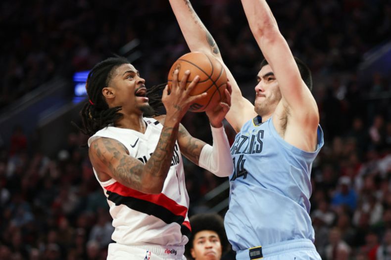Ja Morant (1), escolta de los Trail Blazers de Portland, lleva el balón hacia el aro mientras Zach Edey (14), pívot de los Grizzlies de Memphis, defiende durante la segunda mitad del juego de baloncesto de la NBA, el jueves 29 de octubre de 2026, en Portland, Oregon. (AP Foto/Amanda Loman)