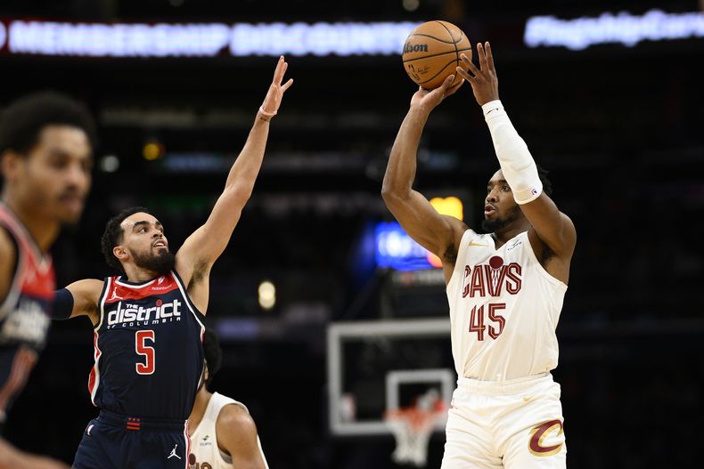 Donovan Mitchell (45), de los Cavaliers de Cleveland, dispara ante el intento defensivo de Tyus Jones (5), de los Wizards de Washington, durante la segunda mitad del juego de baloncesto de la NBA, el miércoles 7 de febrero de 2024, en Washington. (AP Foto/Nick Wass)