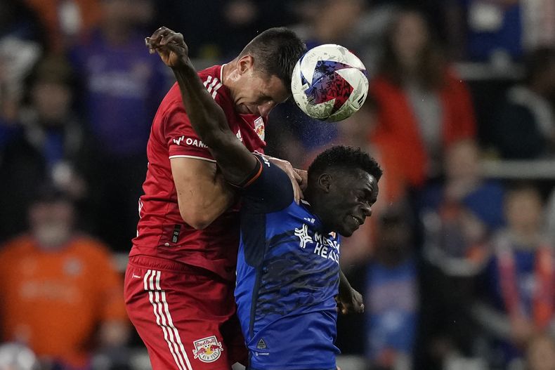Sean Nealis defensa del New York Red Bulls (izquierda) y el delantero del FC Cincinnati Dominique Badji (derecha) disputan de cabeza la pelota durante la primera parte del juego de postemporada en Cincinnati, el domingo 29 de octubre de 2023. (AP Foto/Carolyn Kaster)