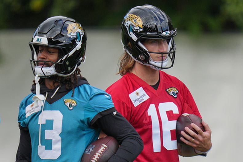 El quarterback Trevor Lawrence y el receptor de los Jaguars de Jacksonville Jakobi Meyers realizan una práctica en Hertfordshire, Inglaterra el miércoles 14 de octubre del 2026. (AP Foto/Kin Cheung)