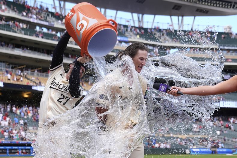 Luke Keaschall de los Mellizos de Minnesota es rociado con agua por Ryan Jeffers (27) después de conectar un jonrón de dos carreras para dejar en el campo a los Reales de Kansas City durante la 11ª entrada de un juego de béisbol el domingo 10 de agosto de 2025, en Mineápolis. (AP Photo/Abbie Parr)