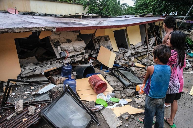 Varias personas observan un edificio derrumbado en Bogo City, en la provincia de Cebu, Filipinas, el 1 de octubre de 2025, tras un sismo la noche anterior. (AP Foto)