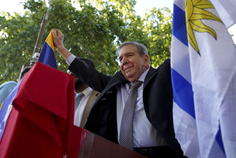 El líder opositor venezolano Edmundo González Urrutia sostiene una bandera uruguaya y otra venezolana frente a la residencia gubernamental en Montevideo, Uruguay, el sábado 4 de enero de 2025. González, quien afirma que ganó las elecciones presidenciales de 2024 y es reconocido por algunos países como el presidente electo legítimo, viajó desde su exilio en Madrid a Argentina y Uruguay. (AP Foto/Matilde Campodónico)
