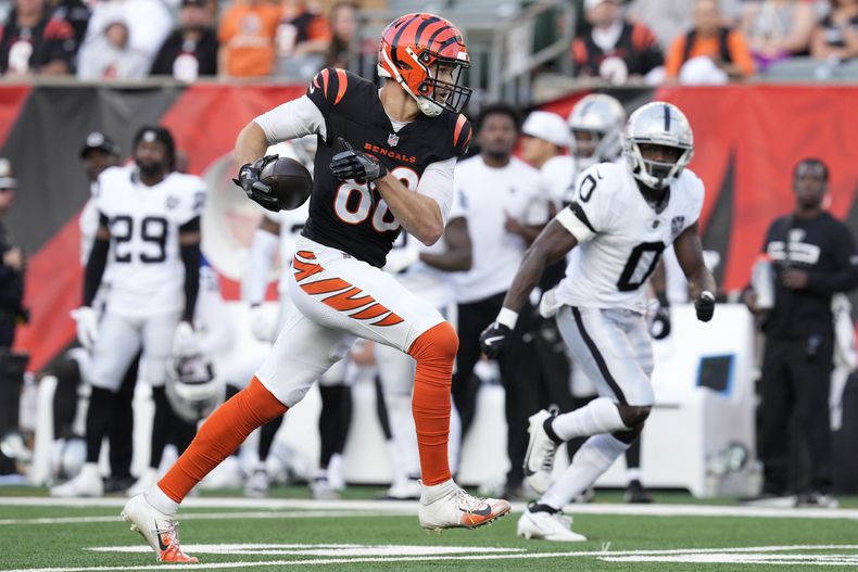 Mike Gesicki, izquierda, tight end de los Bengals de Cincinnati, corre con el balón ante la mirada de Jakorian Bennett (0), cornerback de los Raiders de Las Vegas, durante la segunda mitad del juego de la NFL, el domingo 3 de noviembre de 2024, en Cincinnati. (AP Foto/Jeff Dean)
