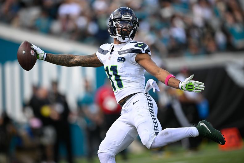 El wide receiver de los Seahawks de Seattle, Jaxon Smith-Njigba (11), atrapa un pase de touchdown en una jugada de pase de 61 yardas durante la primera mitad de un juego de fútbol americano de la NFL contra Los Jaguares de Jacksonville el domingo 12 de octubre de 2025, en Jacksonville, Florida. (AP Photo/Phelan M. Ebenhack)