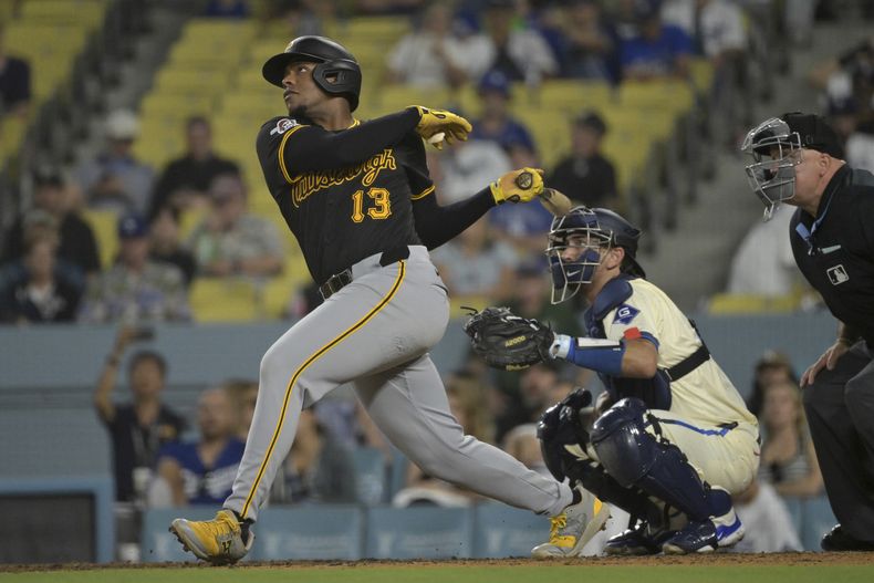 KeBryan Hayes (13), de los Piratas de Pittsburgh, conecta un jonrón solitario mientras Austin Barnes, de los Dodgers de Los Ángeles, mira desde detrás del plato en la novena entrada de un juego de béisbol el sábado 10 de agosto de 2024, en Los Ángeles. (AP Foto/Jayne-Kamin-Oncea)
