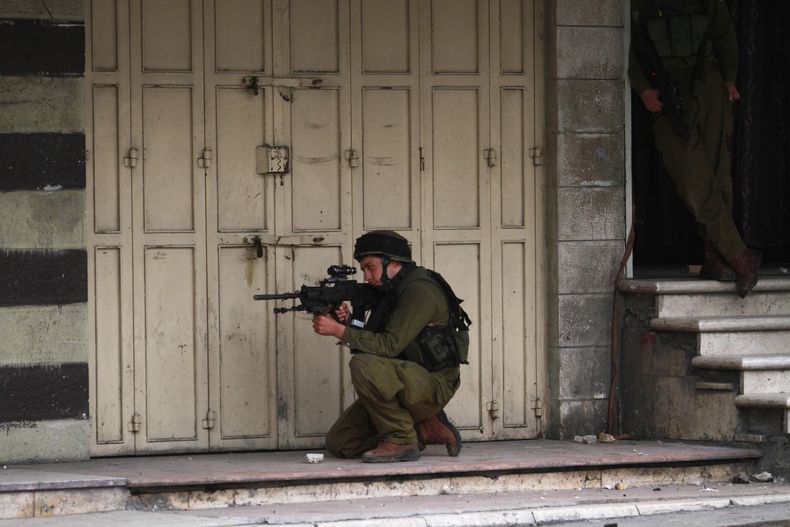 Un soldado israel&iacute; apunta a manifestantes palestinos tras una concentraci&oacute;n a favor del presidente palestino Mahmud Abbas en la ciudad cisjordana de Hebr&oacute;n el lunes, 17 de marzo del 2014. (Foto AP/Nasser Shiyoukhi)