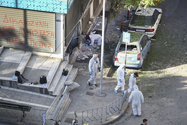 Forenses de la policía griega registran la zona en la que una mujer de 38 años falleció tras explotarle en las manos la bomba que trasladaba, en el exterior de una oficina bancaria, en Salónica, en el norte de Grecia, el 3 de mayo de 2025. (AP Foto/Giannis Papanikos)
