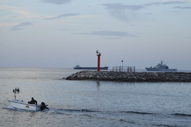 Un barco de la Armada de Italia (derecha) con 49 migrantes a bordo se acerca a puerto, en el tercer intento de llevar a migrantes a Albania luego de fallos judiciales en Italia, en Shengjin, en el noroeste de Albania, el 28 de enero de 2025. (AP Foto/Vlasov Sulaj)