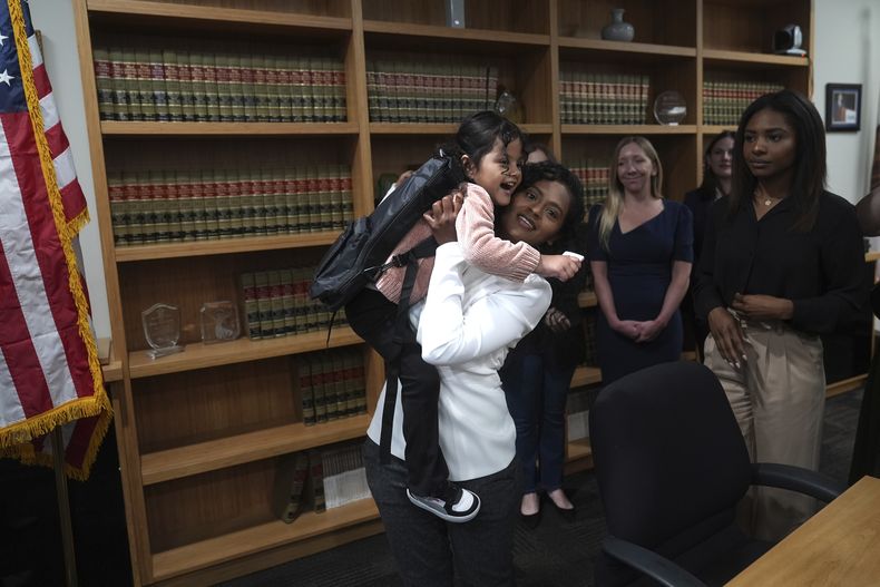 Deysi Vargas carga a su hija de 4 años, quien padece síndrome de intestino corto, en una conferencia de prensa en Los Ángeles, el miércoles 28 de mayo de 2025. (AP Foto/Jae C. Hong)