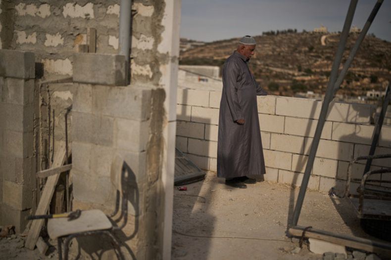 Mahmoud Tubasi se ve pie en la azotea cerca de las dos casas de su familia, quemadas por colonos israelíes en el poblado de Jalud, Cisjordania, el martes 20 de octubre de 2026. (AP Foto/Leo Correa)