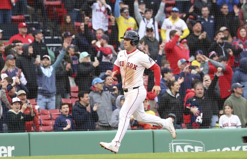 Aficionados de los Medias Rojas de Boston celebran a Alex Bregman mientras recorre las bases tras el sencillo remolcador de Wilyer Abreu en la décima del primer juego de la doble cartelera ante los Cardenales de San Luis el domingo 6 de abril del 2025. (AP Foto/Mark Stockwell)