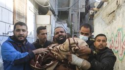 Palestinos cargan con un niño muerto en un bombardeo israelí sobre Rafah, en la Franja de Gaza, el 7 de diciembre de 2023. (AP Foto/Hatem Ali)