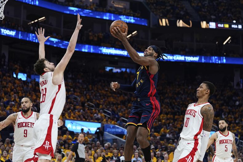 El base de los Warriors de Golden State Buddy Hield lanza el balón sobre el pívot de los Rockets de Houston Alperen Sengun en el juego 4 de la serie de primera ronda de los playoffs el lunes 28 de abril del 2025. (AP Foto/Godofredo A. Vásquez)