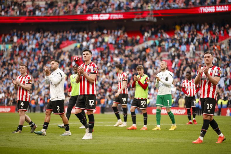 Jugadores de Sheffield United aplauden a los fanáticos al final del partido por las semifinales de la FA Cup en contra del Manchester City y Sheffield United en el Estadio Wembley, en Londres, el sábado 22 de abril de 2023. (AP Foto/David Cliff)