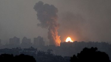 Fuego y humo salen luego de un ataque israelí en la Franja de Gaza visto desde el sur de Israel, el sábado 28 de octubre de 2023. (AP Foto/Ilan Assayag)