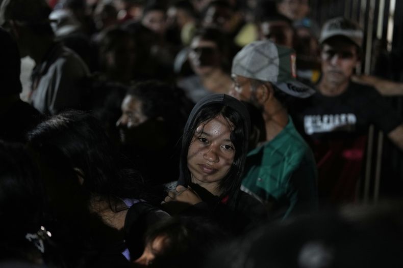 Personas desplazadas por la violencia en localidades de la región del Catatumbo, donde rebeldes del Ejército de Liberación Nacional (ELN) se han enfrentado con exmiembros de las Fuerzas Armadas Revolucionarias de Colombia, hacen fila para registrarse y buscar refugio en un estadio de fútbol en Cúcuta, Colombia, el domingo 19 de enero de 2025. (Foto AP/Fernando Vergara)