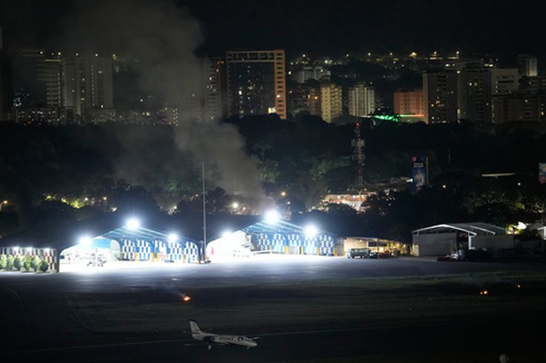 Columnas de humo en el aeropuerto La Carlota tras las explosiones y el paso de aeronaves a baja altura en Caracas, Venezuela, el sábado 3 de enero de 2026. (AP Foto/Matias Delacroix)