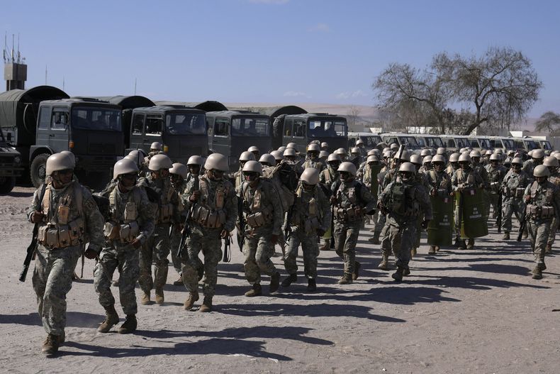 Militares peruanos se despliegan en la frontera del país con Chile, en Tacna, Perú, el viernes 28 de abril de 2023. La crisis migratoria en la frontera entre Chile y Perú se intensificó el jueves con cientos de migrantes que quedaron varados en el límite fronterizo, sin poder cruzar a Perú. (AP Foto/Martín Mejía)