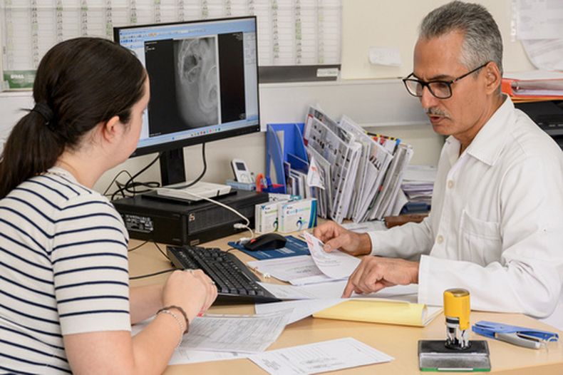 El doctor cubano Raciel Escalona Zaldivar, a la derecha, habla con una paciente en una unidad de ortopedia en el Hospital Santa Maria degli Ungheresi de Polistena en la región sureña italiana de Calabria, el 16 de junio de 2026. (AP Foto/Valeria Ferraro)