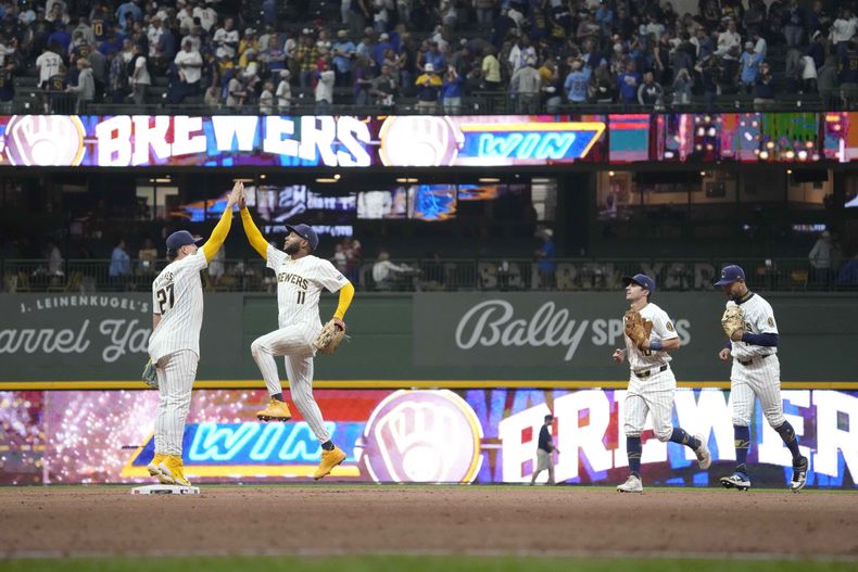 El campocorto de los Cerveceros de Milwaukee, Willy Adames (27), choca los cinco con el jardinero izquierdo Jackson Chourio (11) mientras el jardinero derecho Sal Frelick (10) y el jardinero central Blake Perkins, a la derecha, salen corriendo del campo después de una victoria sobre los Rockies de Colorado, el sábado 7 de septiembre de 2024, en Milwaukee. (AP Foto/Kayla Wolf)