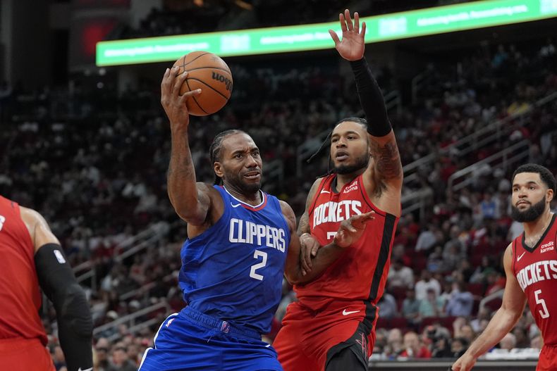 Kawhi Leonard (2), de los Clippers de Los Ángeles, se dispone a tomar un tiro mientras Cam Whitmore, de los Rockets de Houston, defiende durante la segunda mitad del juego de baloncesto de la NBA, el miércoles 6 de marzo de 2024, en Houston. (AP Foto/David J. Phillip)
