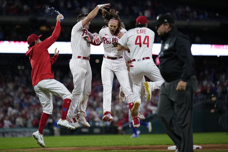 Alec Bohm, de los Filis de Filadelfia, festeja con sus compañeros tras conectar el hit decisivo en el juego del viernes 22 de septiembre de 2023, ante los Mets de Nueva York (AP Foto/Matt Slocum)