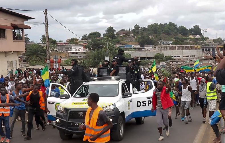 ARCHIVO - Esta imagen tomada de un video muestra a partidarios del golpe de Estado festejando delante de la policía, el miércoles 30 de agosto de 2023, en Libreville, Gabón. (AP Foto/Betiness Mackosso, archivo)