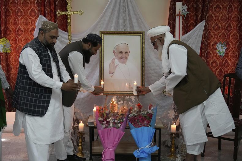 Clárigos musulmanes colocan velas ante un retrato del papa Francisco durante un acto para rendir tributo al fallecido pontífice en Lahore, Pakistán, el 22 de abril de 2025. (AP Foto/K.M. Chaudary)