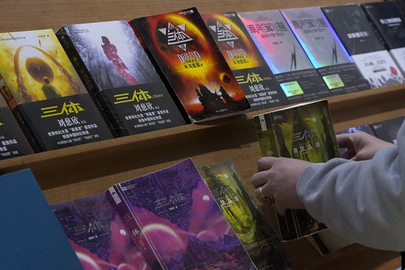 Un hombre mira copias de El problema de los tres cuerpos expuestas en una librería en Beijing el lunes 19 de febrero de 2024. La serie, escrita por el ingeniero Liu Cixin, ayudó a la ciencia ficción china a abrirse paso a nivel internacional, ganando premios y llegando a las listas de lectura de personas como el ex presidente estadounidense Barack Obama y Mark Zuckerberg. (Foto AP/Andy Wong)