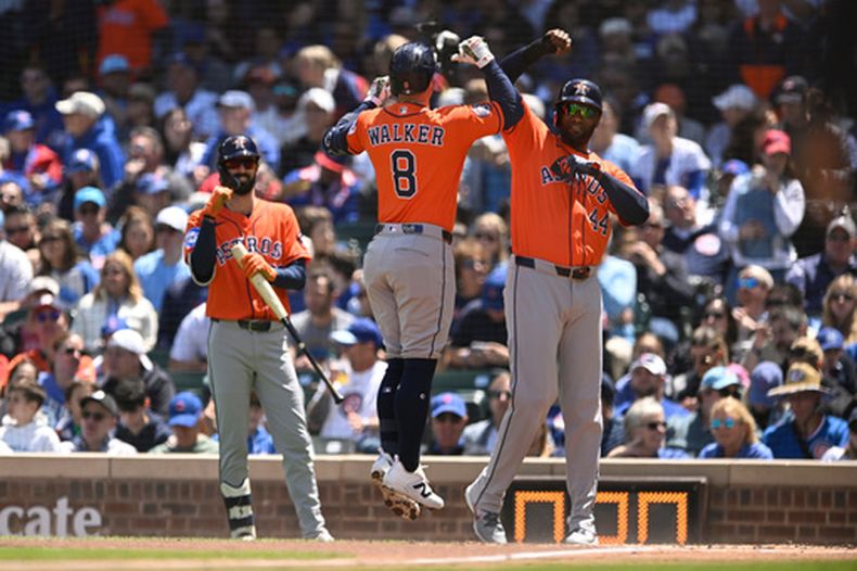 Christian Walker (8), de los Astros de Houston, celebra con Yordan Álvarez (44) tras conectar un jonrón de dos carreras durante la primera entrada de un partido de béisbol contra los Cachorros de Chicago en Chicago, el sábado 23 de mayo de 2026. (Foto AP/Paul Beaty)