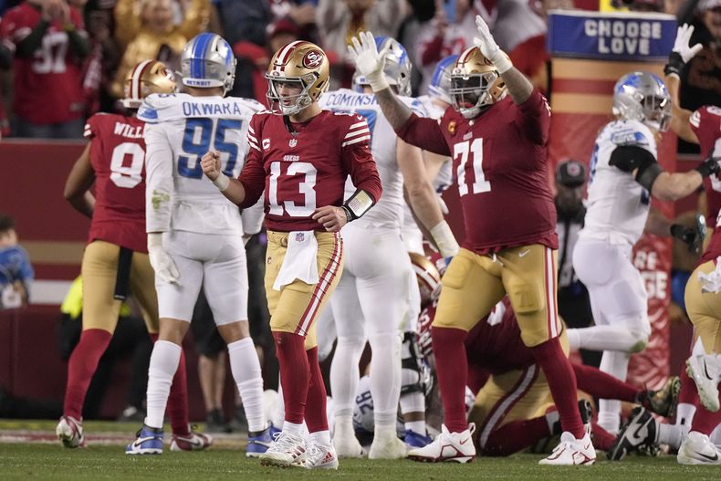 Brock Purdy (13), quarterback y Trent Williams (71), left tackle, de los 49ers de San Francisco, celebran después de un acarreo de touchdown de Christian McCaffrey durante la segunda mitad del Juego de Campeonato de la NFC en contra de los Lions de Detroit en Santa Clara, California, el domingo 28 de enero de 2024. (AP Foto/Mark J. Terrill)