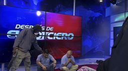 Imagen extraída del vídeo emitido por el canal TC Televisión en el que aparece un hombre encapuchado y armado al lado de dos trabajadores del medio en plena retransmisión en vivo, en Guayaquil, Ecuador, el martes 9 de enero de 2024. El país ha registrado una secuencia de ataques violentos desde que el gobierno decretara el estado de excepción el lunes 8 de enero, tras la presunta fuga de un peligroso cabecilla de una banda criminal que opera en el país. (TC Televisión vía AP)