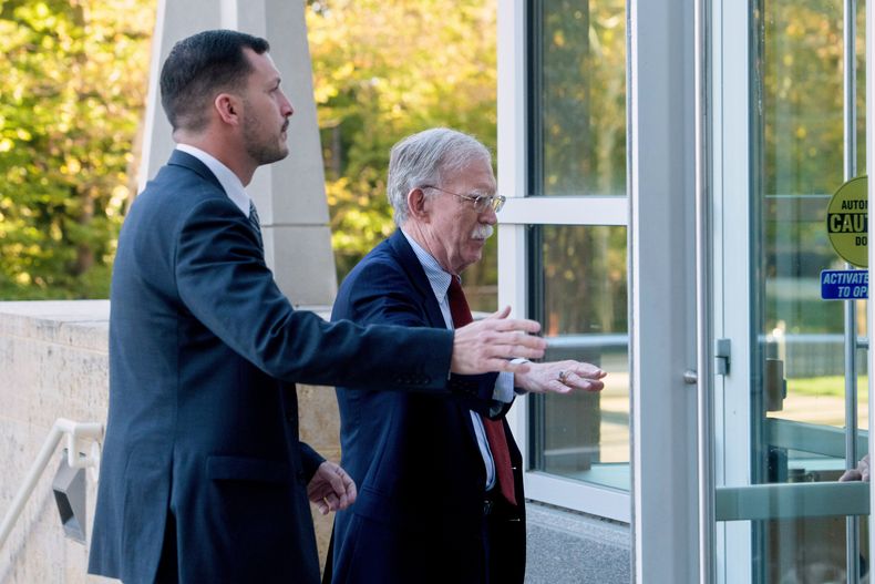 El exasesor de seguridad nacional del gobierno de Trump, John Bolton, derecha, llega para comparecer ante un juez en el tribunal federal de Greenbelt, en esa ciudad de Maryland, el viernes 17 de octubre de 2025. (AP Foto/Rod Lamkey, Jr.)