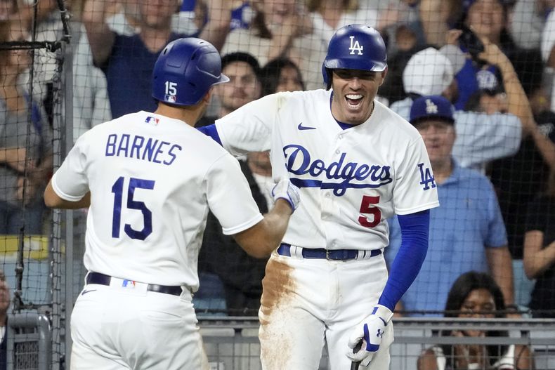 Austin Barnes, de los Dodgers de Los Ángeles, festeja con Freddie Freeman, luego de conectar un jonrón el jueves 17 de agosto de 2023, en el juego ante los Cerveceros de Milwaukee (AP Foto/Mark J. Terrill)
