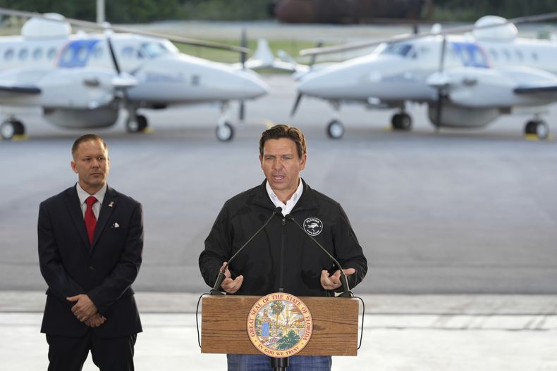 El gobernador de Florida Ron DeSantis habla en compañía de Keith Pearson, un asesor senior del Departamento de Seguridad Nacional, en conferencia de prensa en el hangar de la Oficina de Aduanas y Protección Fronteriza de Estados Unidos (CBP, por sus siglas en inglés) en la Base de la Fuerza Aérea en Homestead, Florida, el miércoles 26 de febrero de 2025. (AP Foto/Rebecca Blackwell)